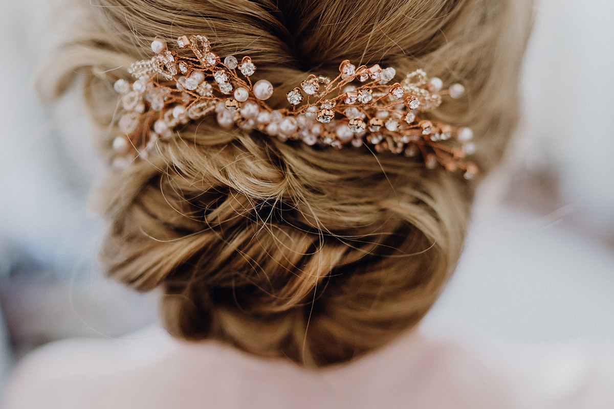 Detailaufnahme Brautfrisur: Dutt mit Haarschmuck in Rosegold