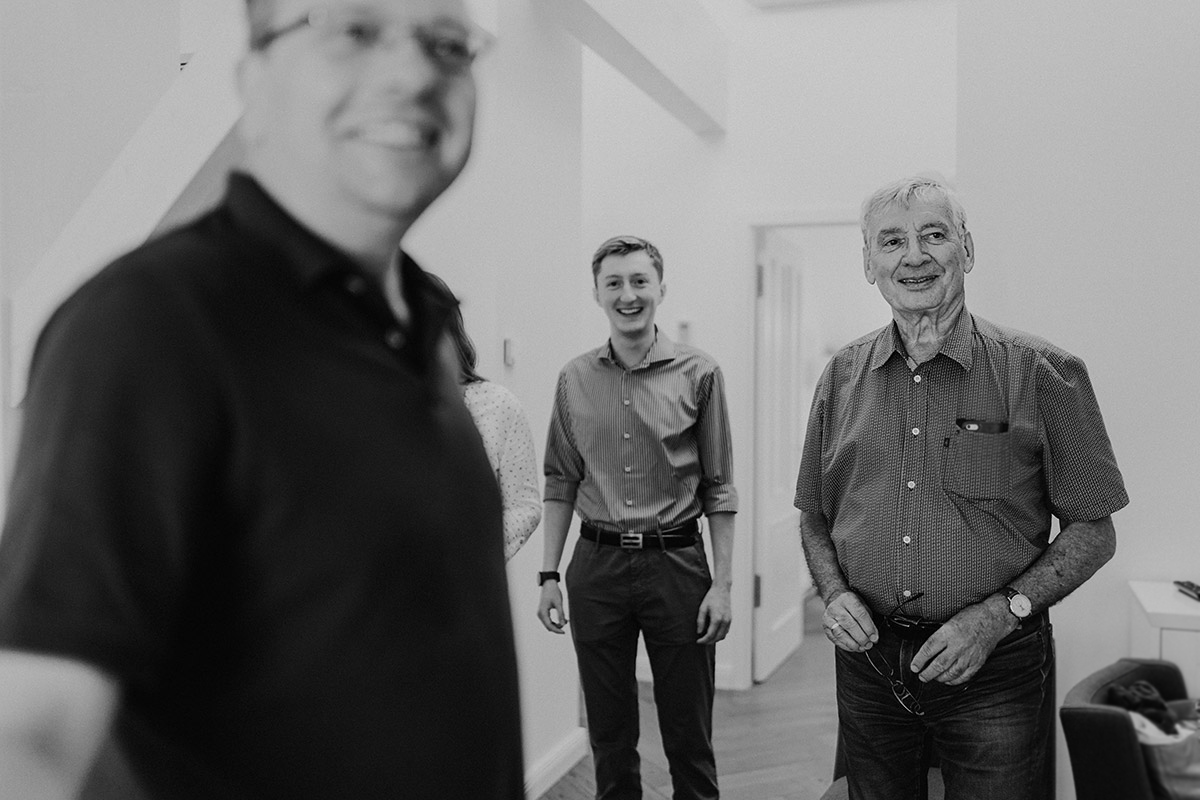 Reportagefoto: Gäste schauen erwartungsvoll zum Bräutigam in Schwarz-Weiß