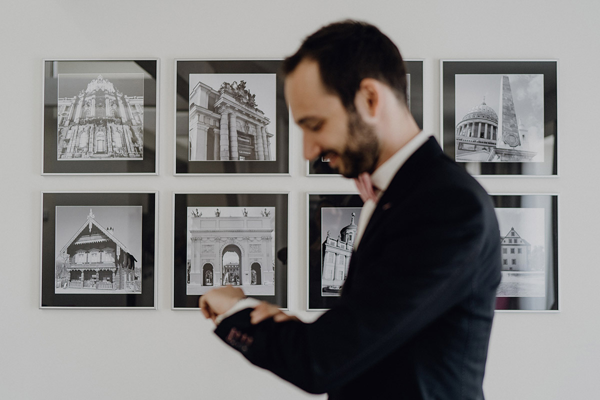 Kreatives Getting Ready Foto: Fokus auf Wandstruktur im Hotel, Bräutigam unscharf im Hintergrund