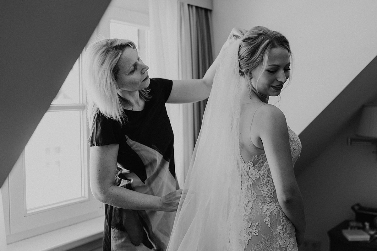 Emotionaler Moment: Brautmutter steckt den Schleier der Braut fest
