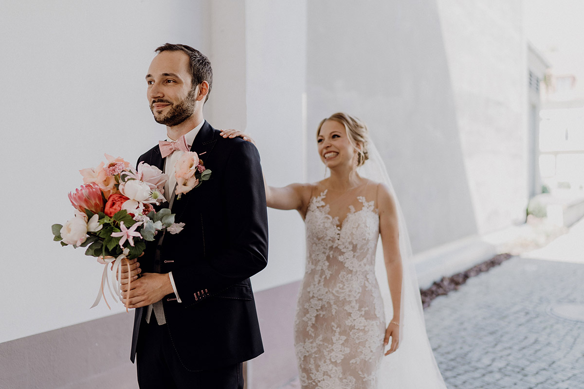 First Look Brautpaar: Braut tippt Bräutigam aufgeregt auf die Schulter