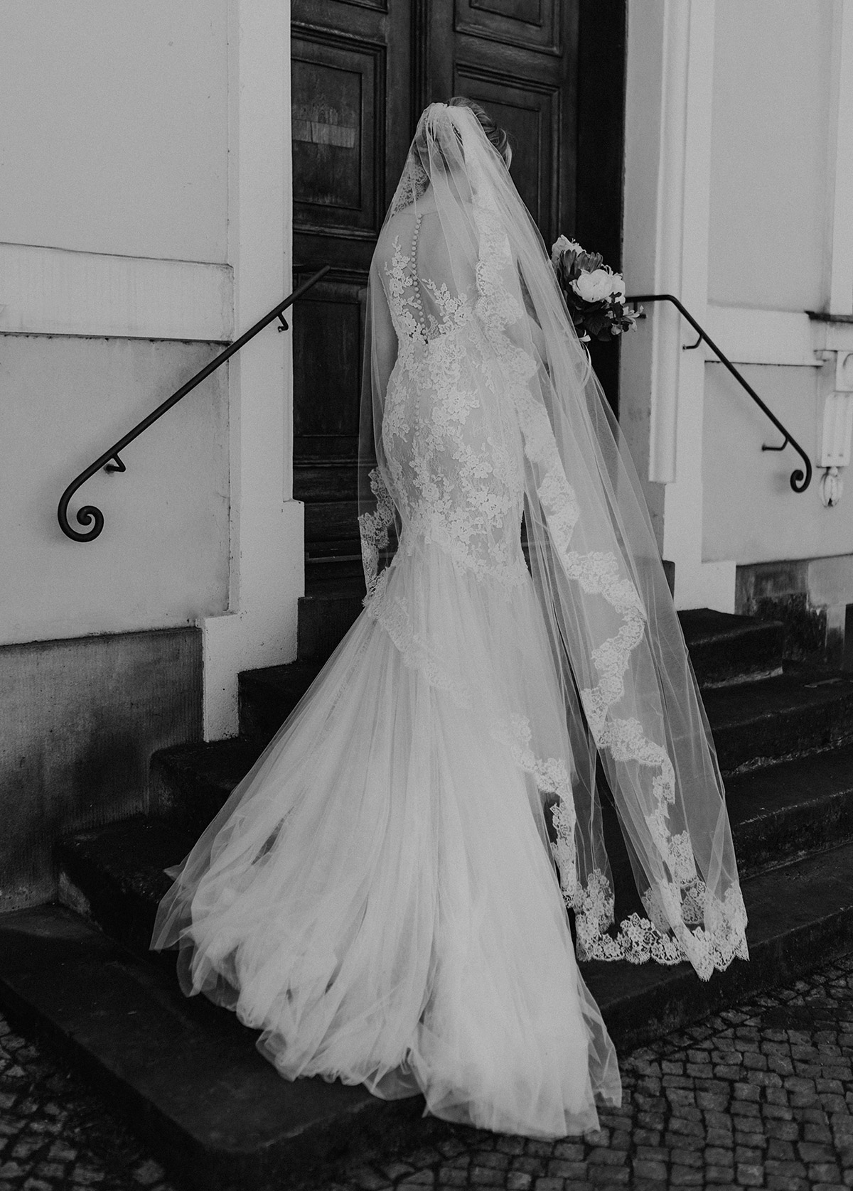 Potsdam Braut von hinten mit langem Pronovias Schleier und Hochzeitskleid im Meerjungfrauenschnitt