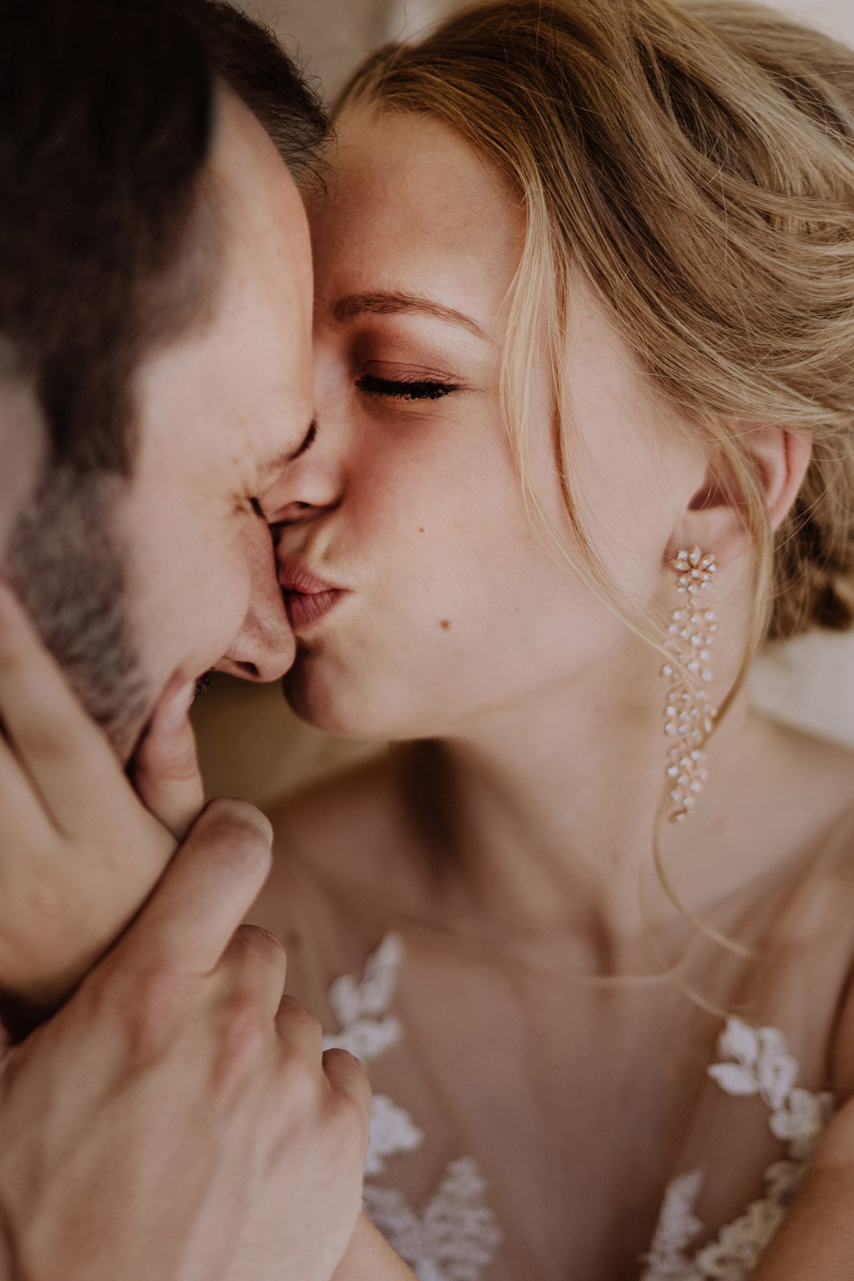 Intime Brautpaarfoto Idee: Braut küsst Bräutigam zärtlich auf den Nasenrücken