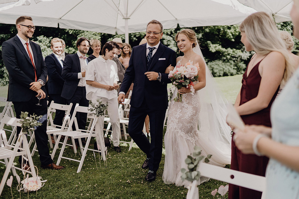 Freie Trauung auf der Wiese des Gästehauses Blumenfisch: Einzug der Braut mit Vater