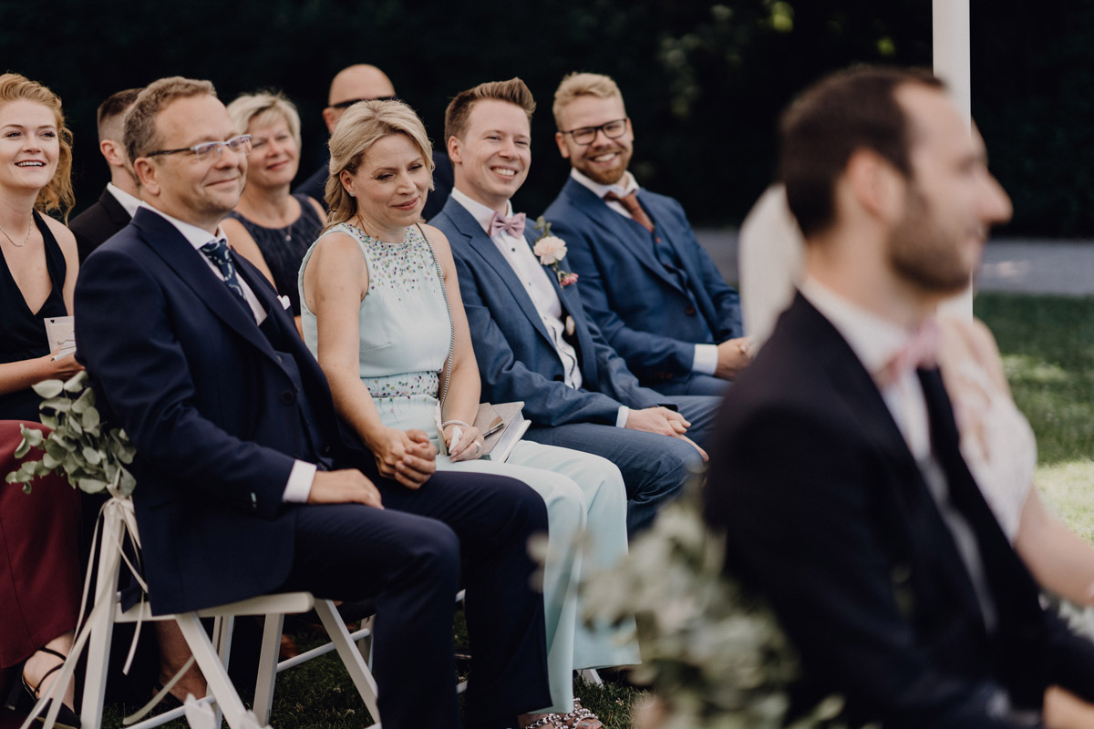 Hochzeitsgäste sitzen und verfolgen bewegt die freie Trauung