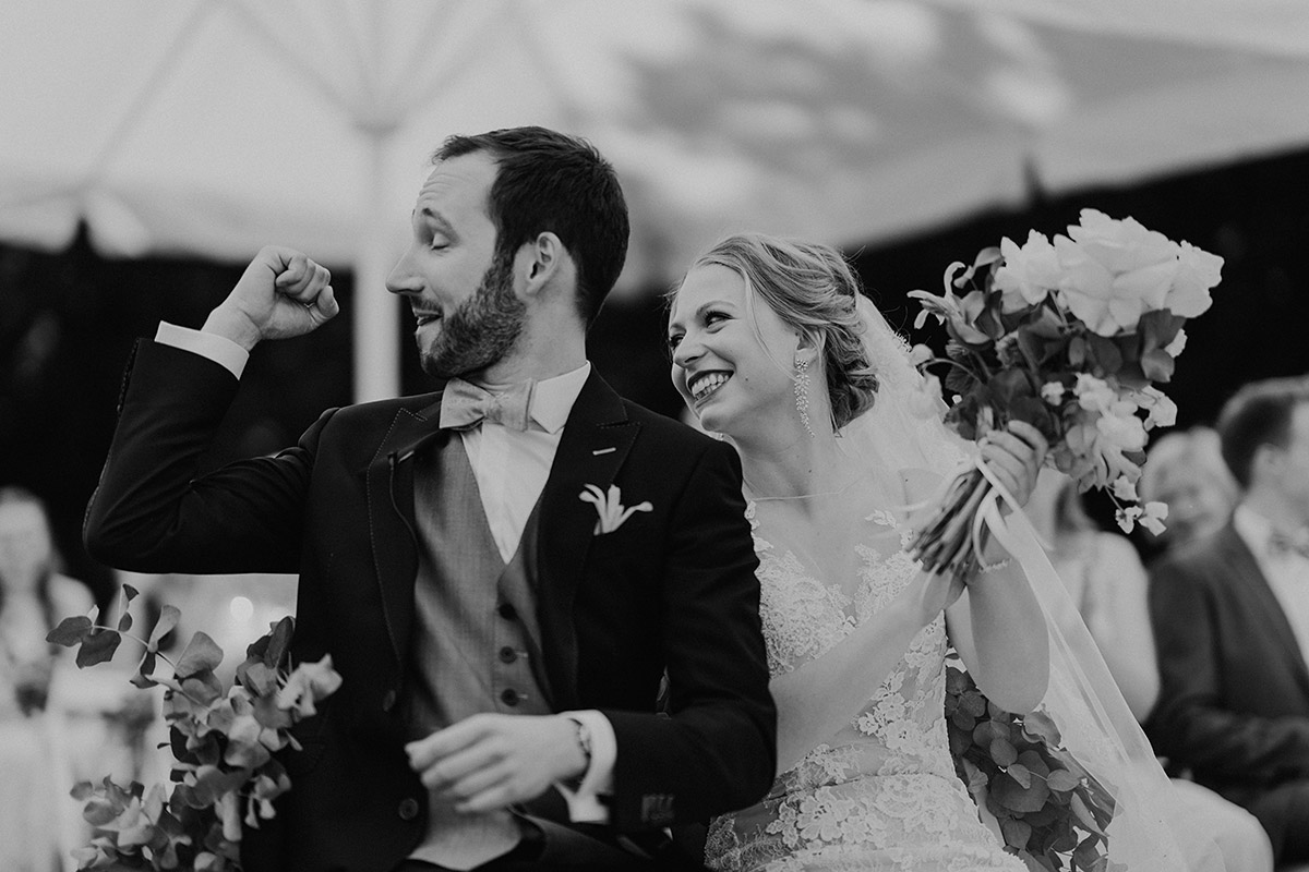 Blumenfisch Hochzeit: Bräutigam hebt nach dem Ja-Wort feiernd den Arm