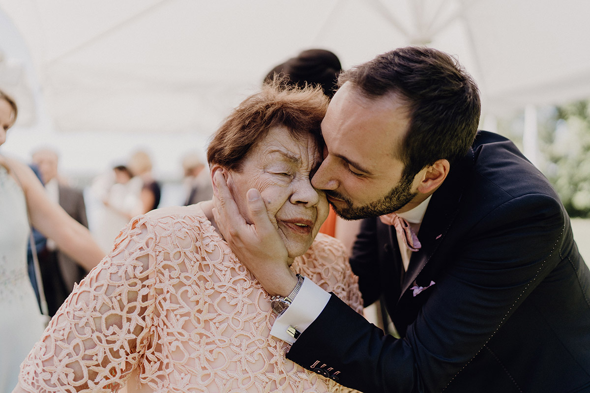 Herzlicher Moment: Bräutigam küsst Oma als Blumenmädchen beim Auszug