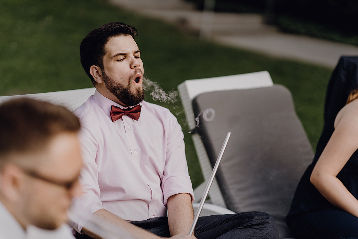 Hochzeitsgast genießt Shisha in der Abendsonne