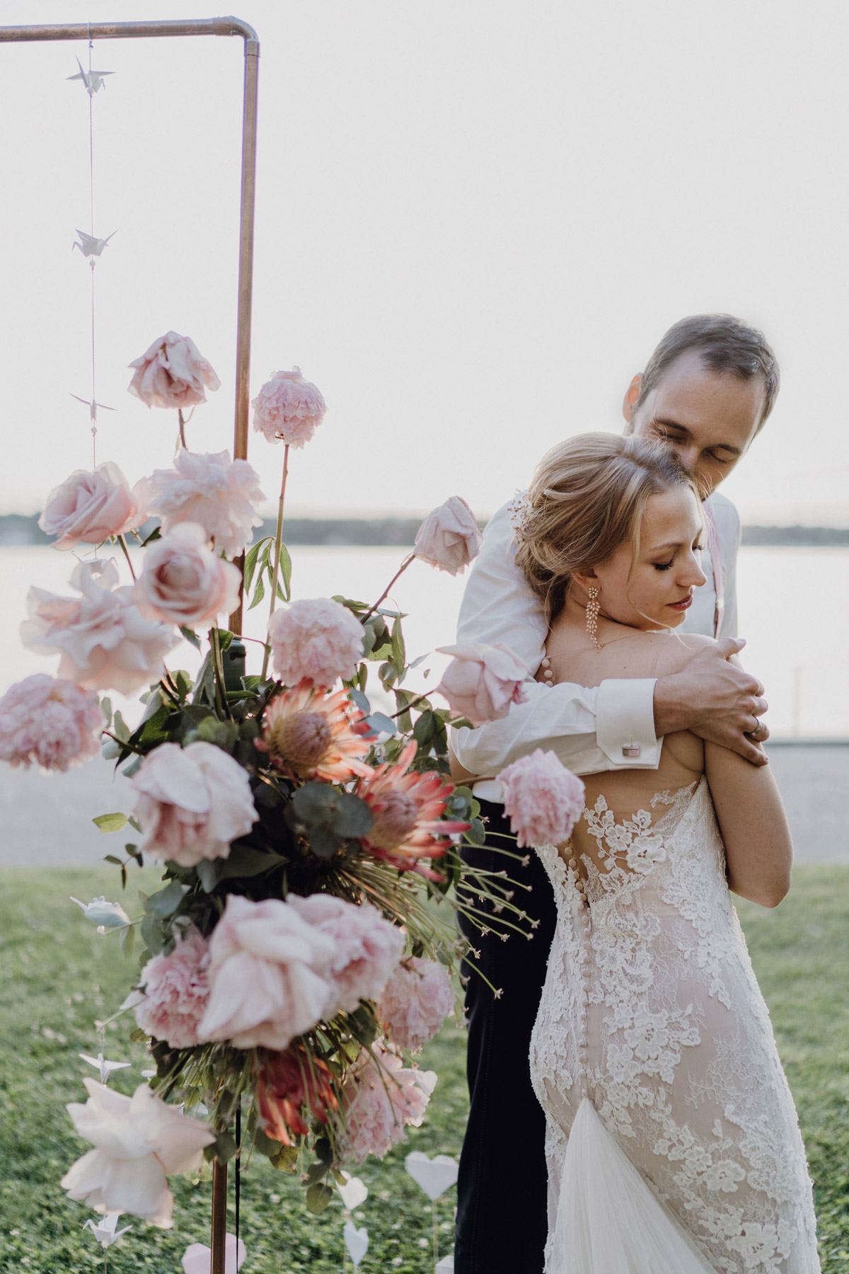 Hochzeitsfoto Gästehaus Blumenfisch: Bräutigam nimmt seine Braut beim Shooting am Wannsee Berlin in den Arm
