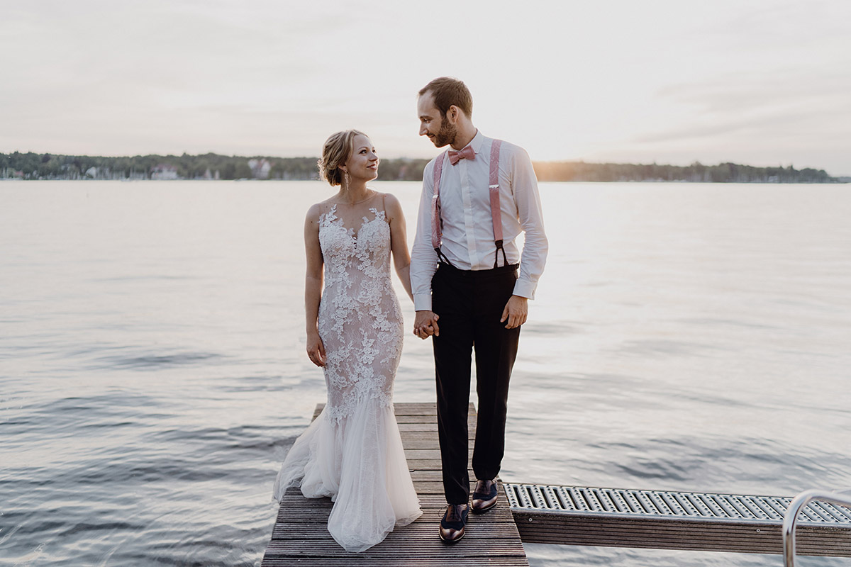 Gästehaus Blumenfisch Hochzeit: Brautpaar steht romantisch auf dem Steg am Wannsee