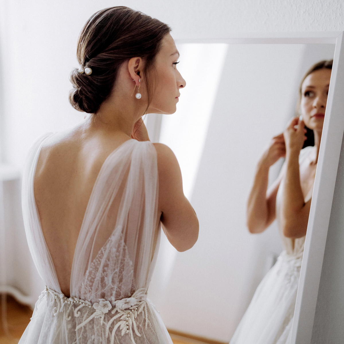 Braut bei der Vorbereitung am Spiegel mit Ohrringen von Juwelier Lorenz Berlin; Fine Art Hochzeitsfoto.