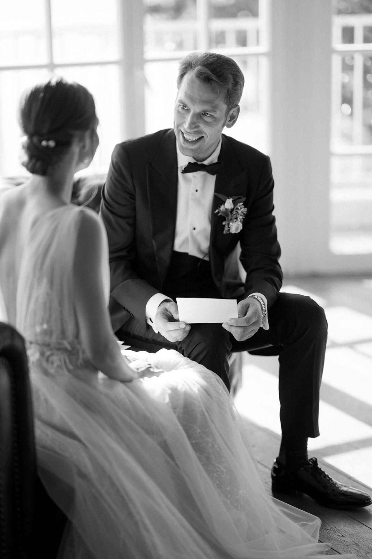 Bräutigam lächelt Braut beim Vorlesen des Eheversprechens an