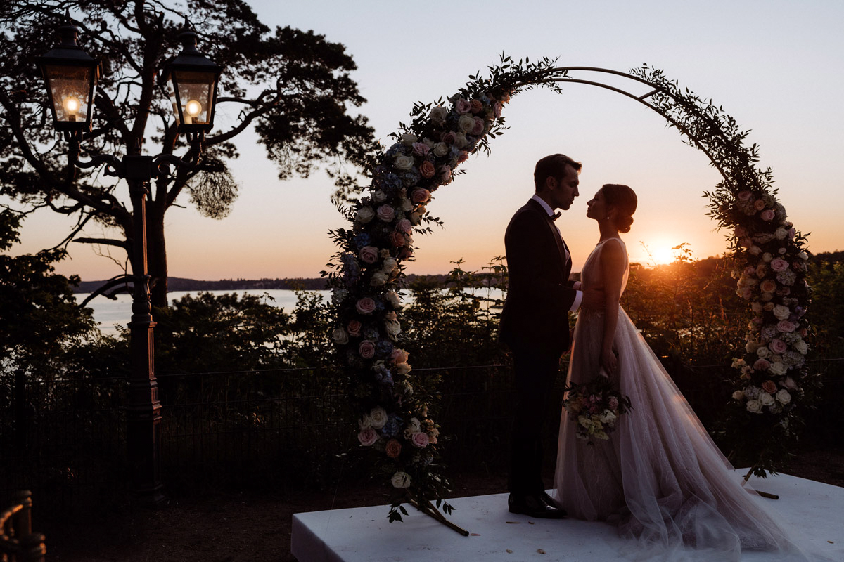 Hochzeit Wannseeterrassen Berlin mit Paar als Silhouette im Sonnenuntergang festgehalten von Hochzeitsfilmer und -fotografin