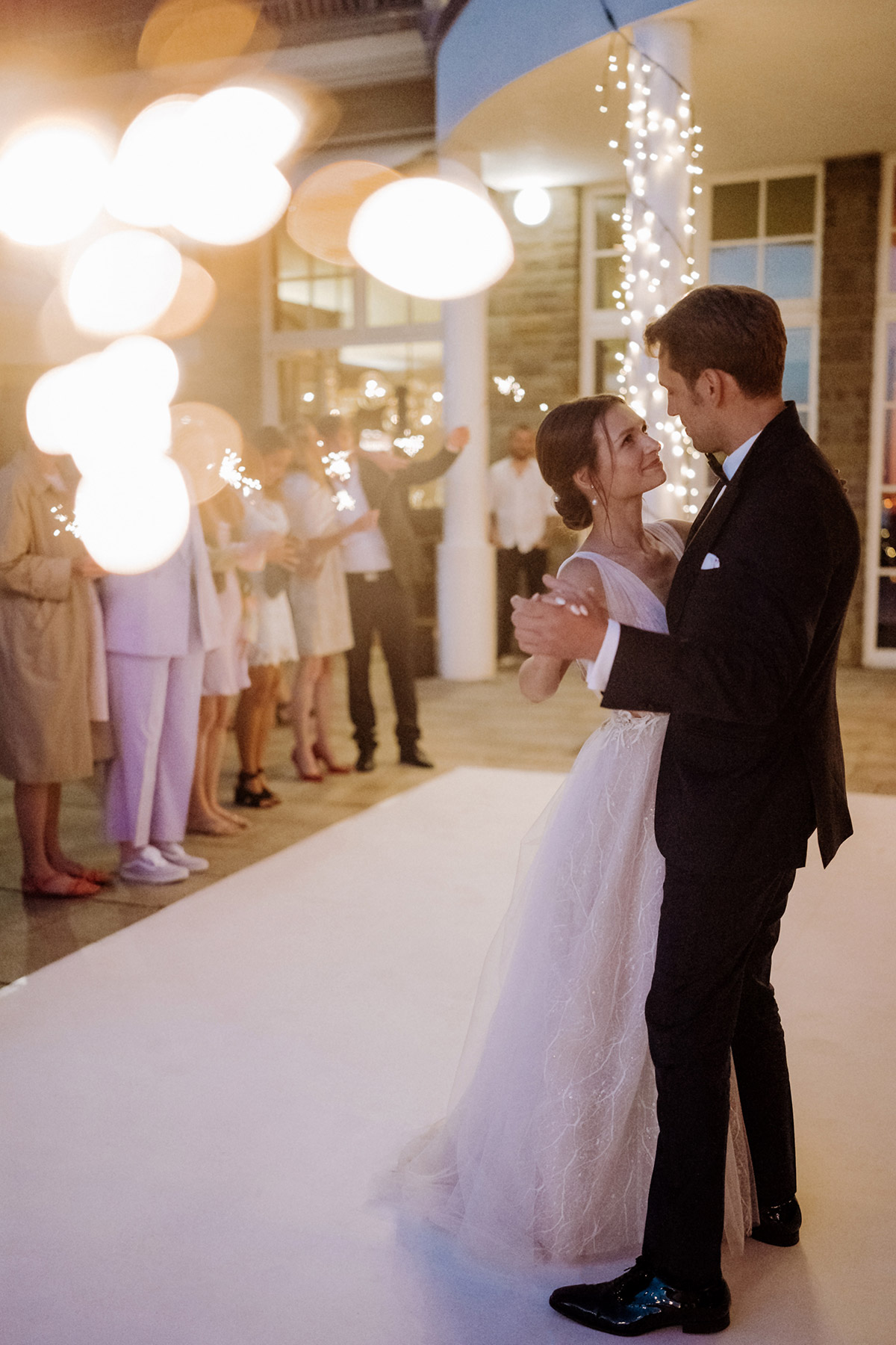 Hochzeitsreportage Wannseeterrasse Berlin: Brautpaar tanzt mit leuchtenden Wunderkerzen