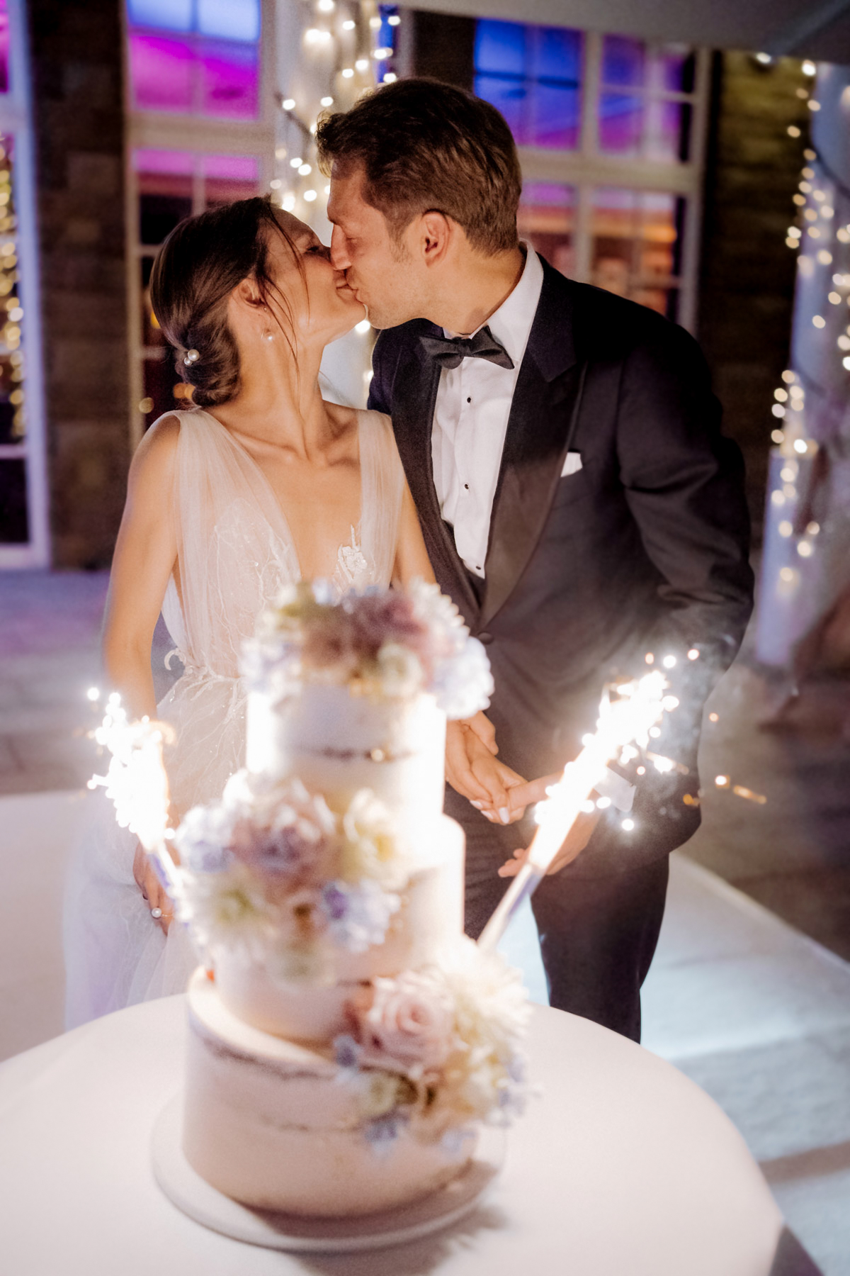 Hochzeitstorte von Lottas Torten Berlin: Brautpaar küsst sich im Hintergrund – Hochzeitsreportage Melanie Meißner