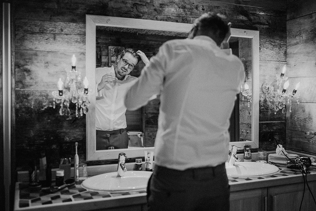 Bräutigam stylt sich die Haare vor Spiegel