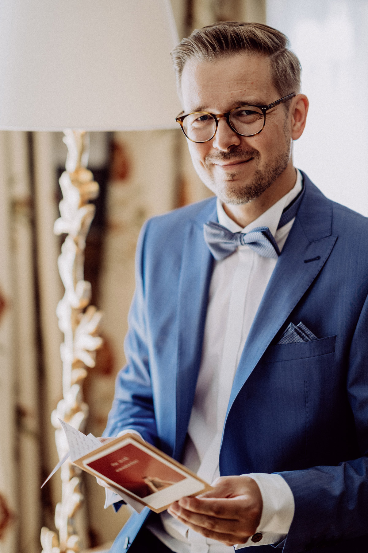 Portrait Bräutigam in blauem Hochzeitsanzug mit Fliege