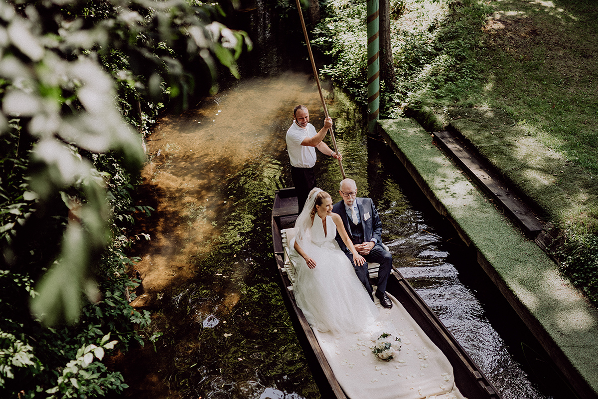 Hochzeit Spreewald: im Kahn stakt Fährman auf Fließ Braut mit Brautvater zur Trauung 