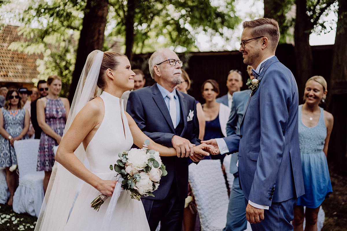Vater überreicht Bräutigam die Hand der Braut