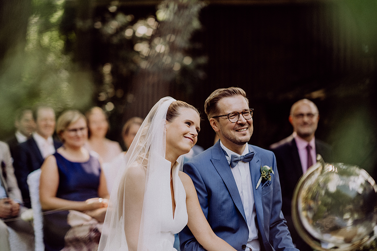 Brautpaar lacht zur Trauung auf Wiese