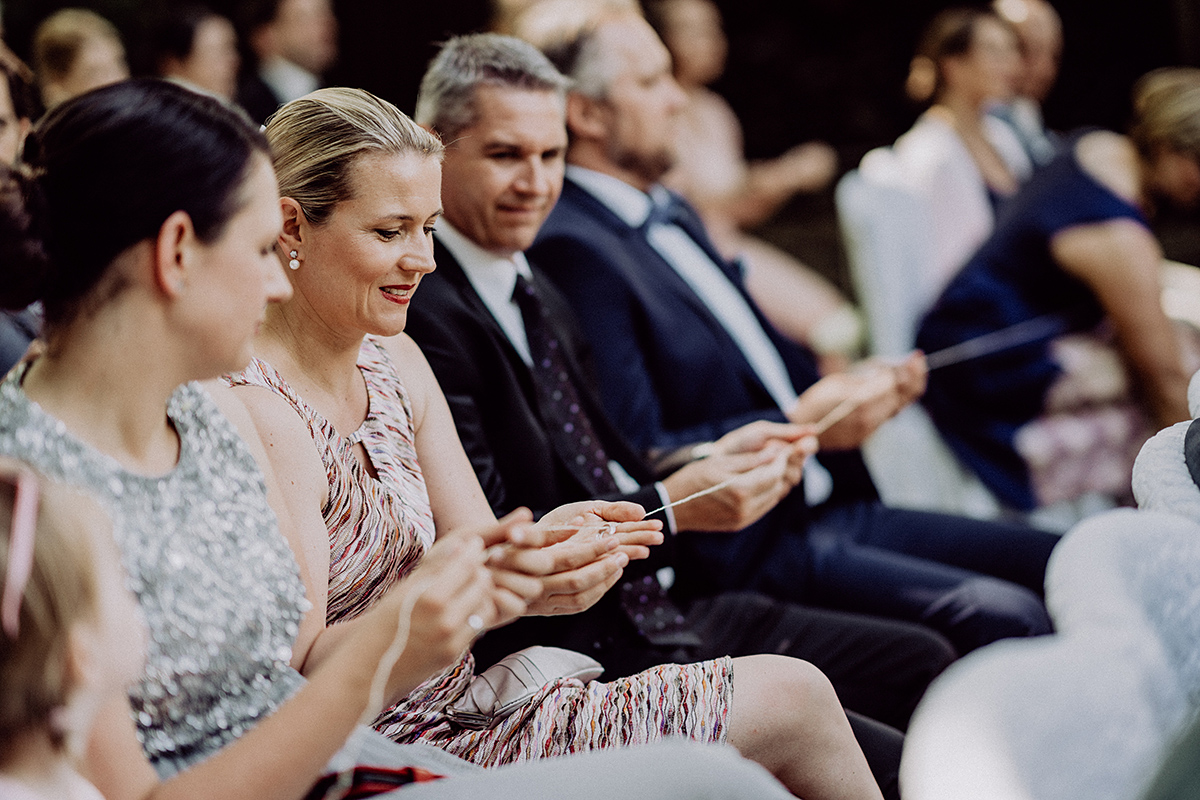 Gäste betrachten Eheringe an Schnur