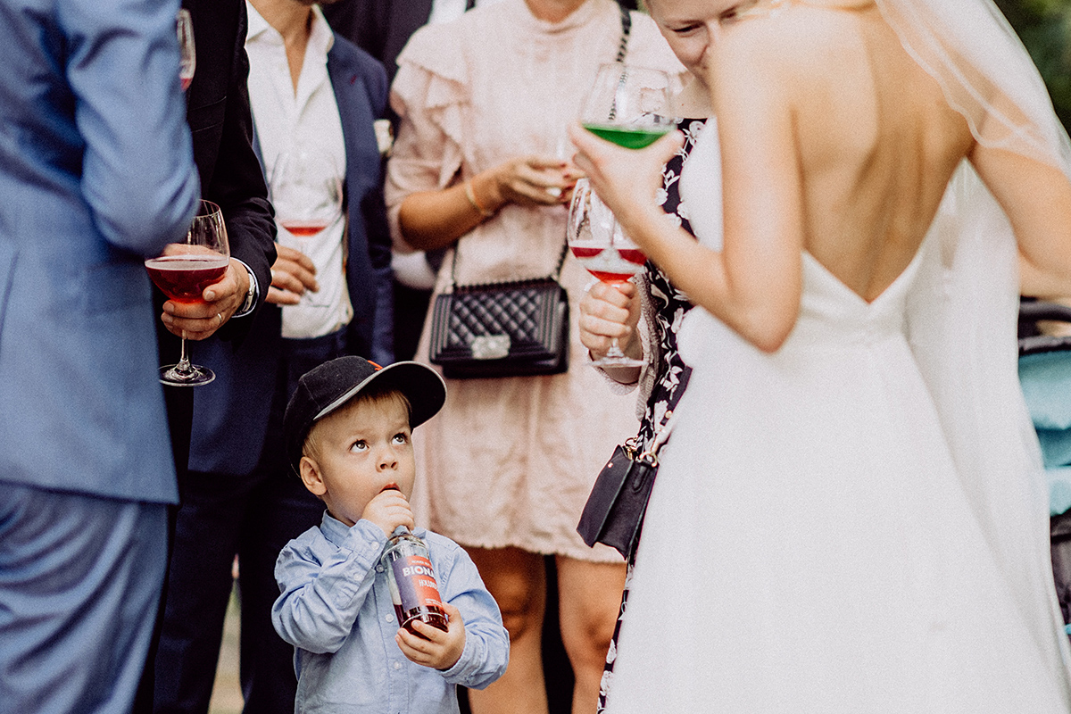 Junge bestaunt während der Gratulation die Braut