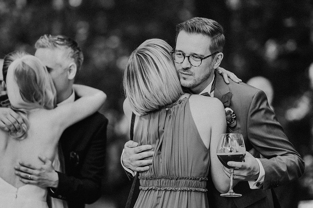 Bräutigam lässt sich von Gratulantin umarmen