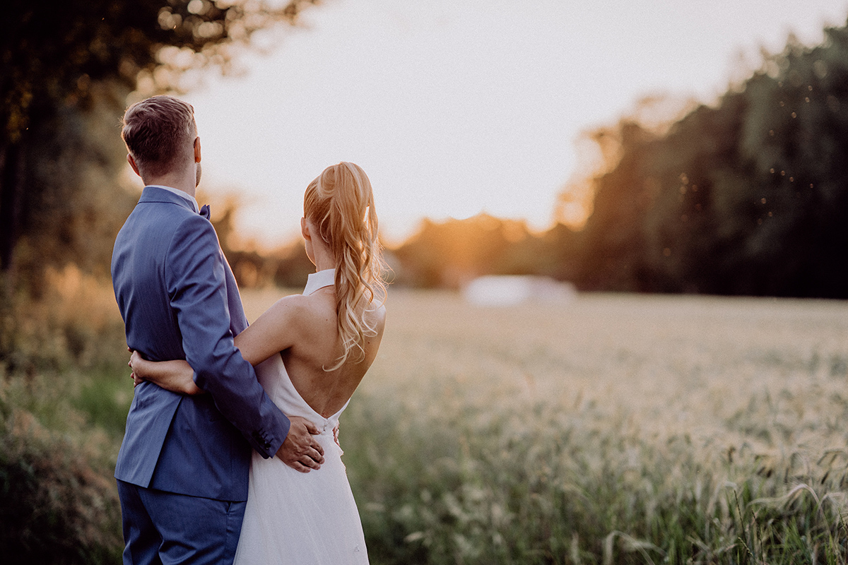 Hochzeitspaar von hinten schaut auf Hotel zur Bleiche & Spa im Spreewald