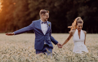 Natürliches Brautpaar-Fotoshooting im Sonnenuntergang auf einem Feld im Spreewald: Vintage Landhochzeit im Hotel zur Bleiche, festgehalten von Hochzeitsfotograf & Videograf Berlin.