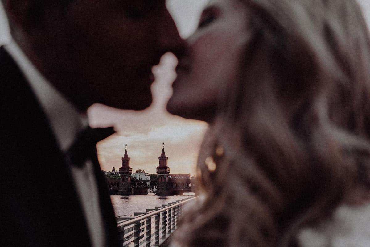 Romantischer Kuss beim Sonnenuntergang an der Oberbaumbrücke: Exklusive Arbeit vom Hochzeitsfotograf Berlin für Elopements