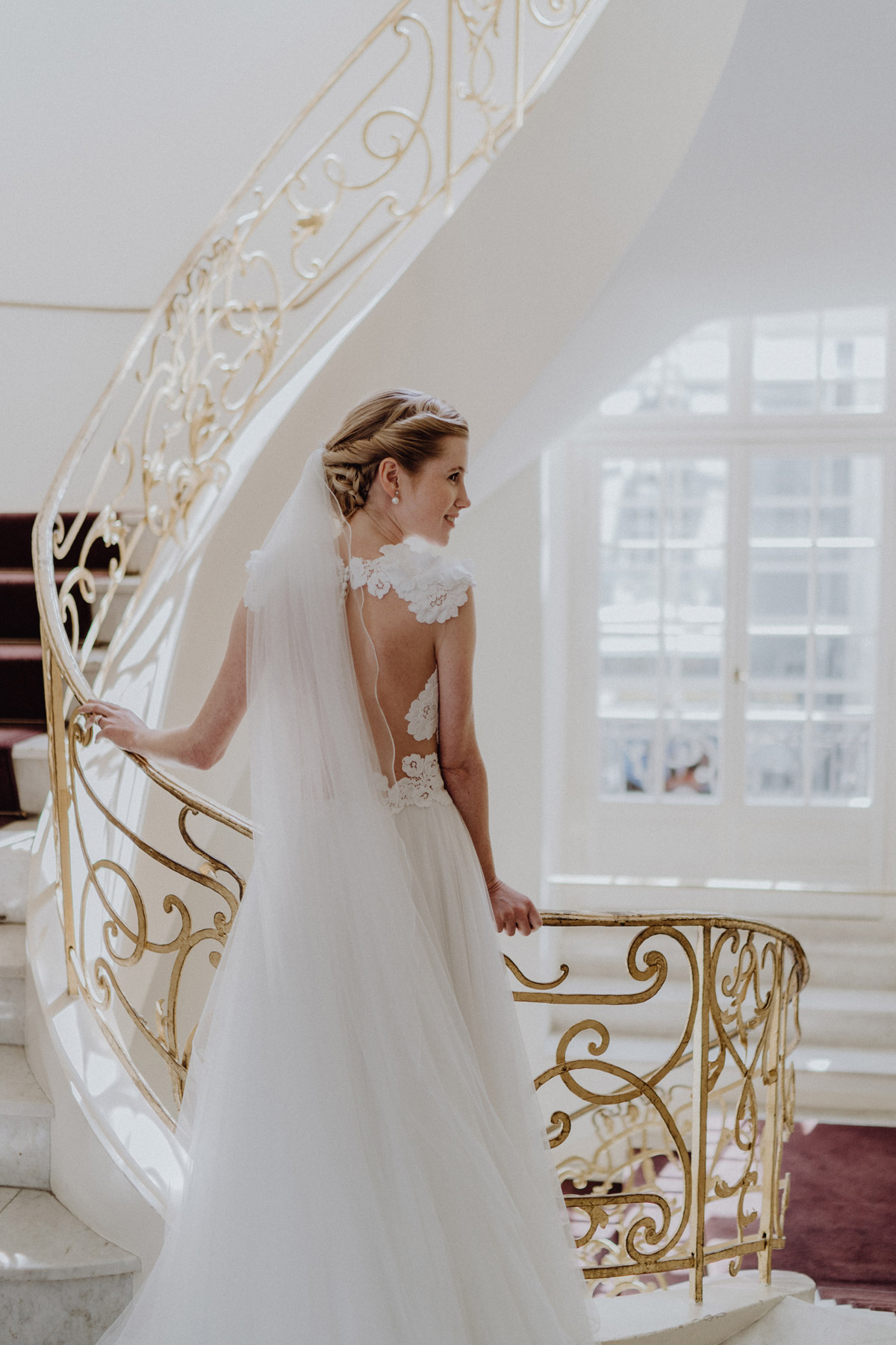 Braut auf der goldenen Wendeltreppe im Ermelerhaus: Exklusive Fotokulisse der Standesamt Berlin Mitte Außenstelle