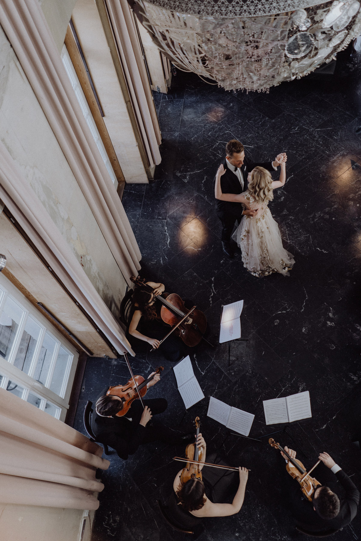 Romantischer Hochzeitstanz im Festsaal des The Grand Berlin: Vogelperspektive auf das Brautpaar und Streichquartett