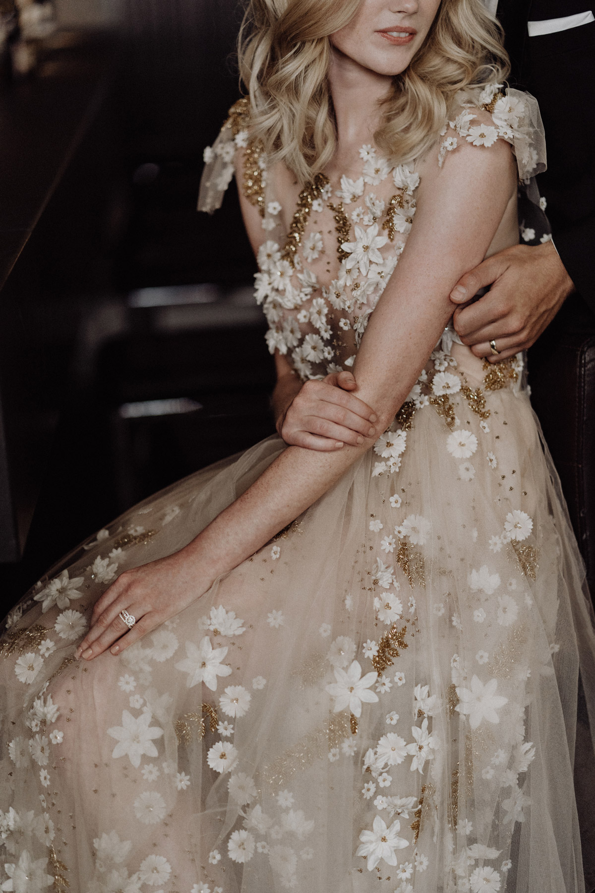 Detailaufnahme des Brautkleides und der Eheringe: Elegante Atmosphäre in der Bar des The Grand Berlin