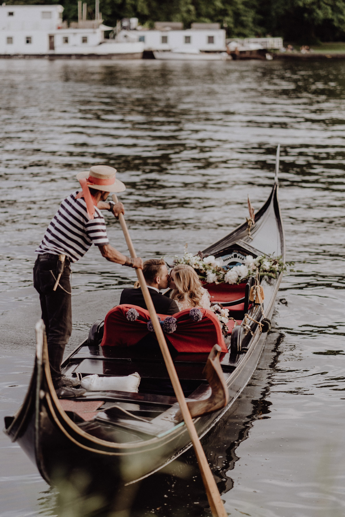 Romantische Berlin Hochzeit auf dem Wasser: Brautpaar küsst sich im Boot (Gondel) auf der Spree