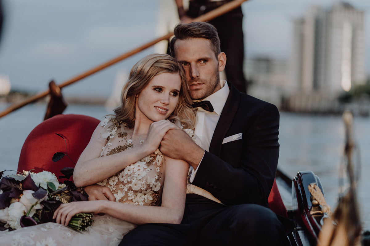 Brautpaar genießt die Bootsfahrt: Elegante Berlin Hochzeit auf der Spree mit Blumenbouquet