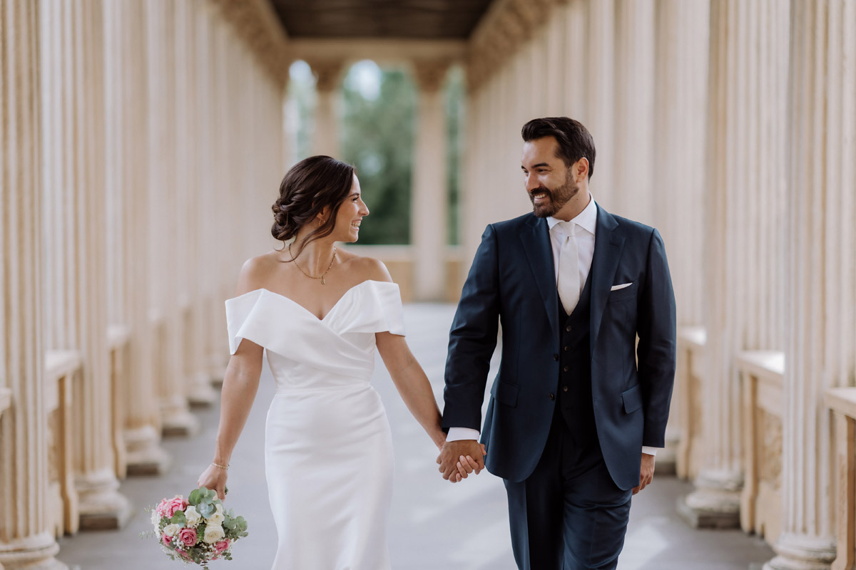 Hochzeitspaar schaut sich im Säulengang an