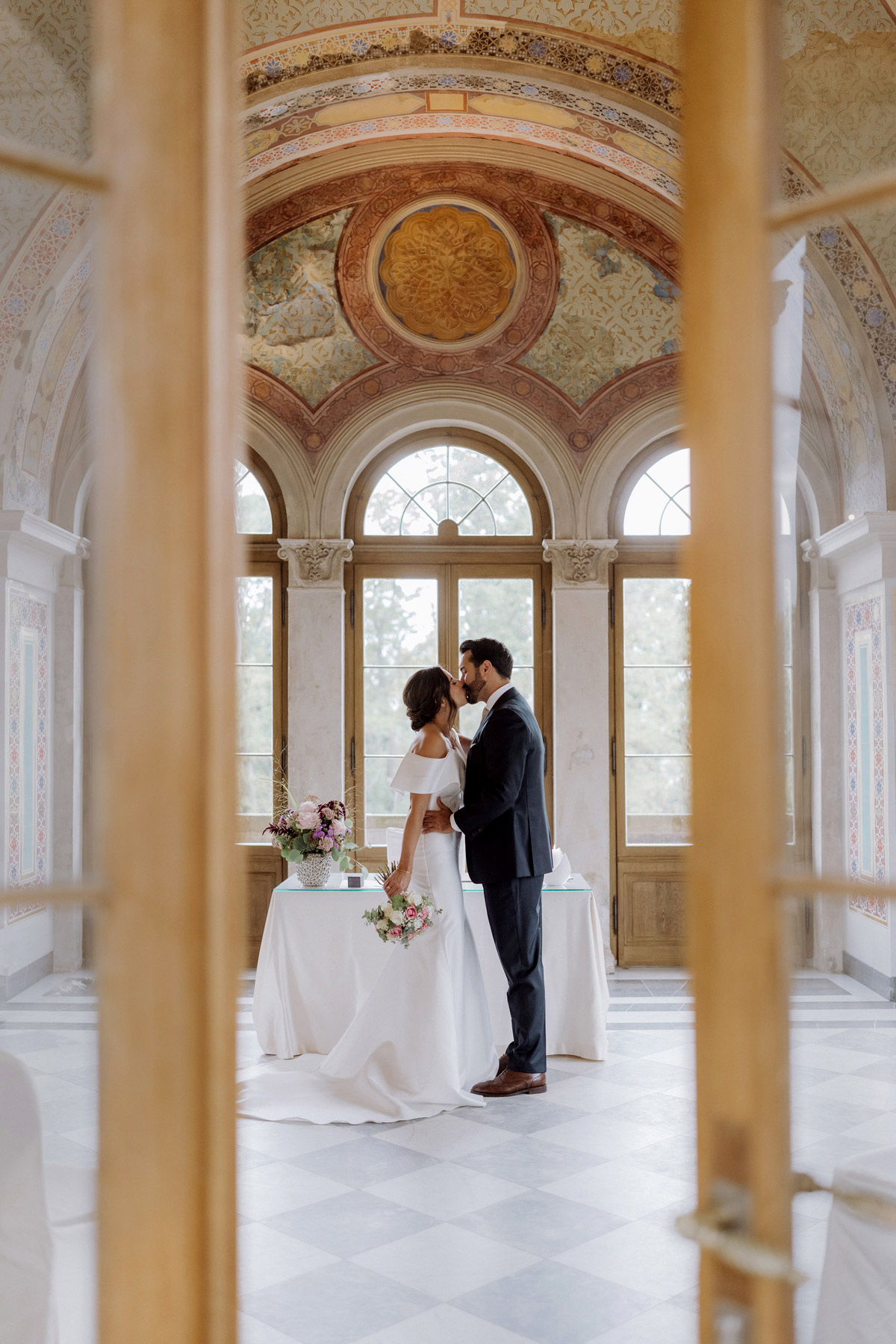 Maurisches Kabinett Hochzeit: Brautpaar küsst sich – Ganzkörper- und Raumaufnahme