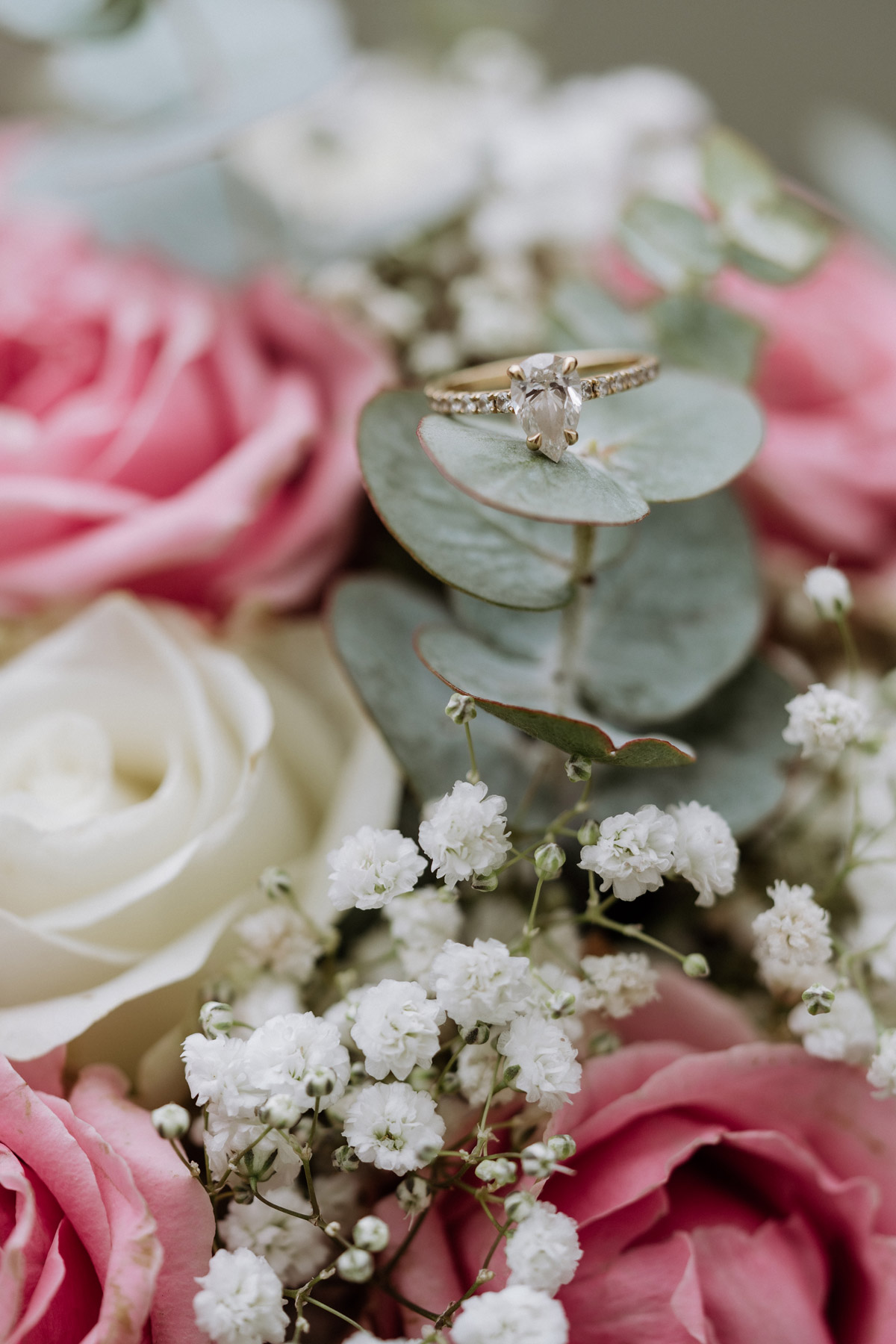 Verlobungsring liegt auf Blume2000 Brautstrauß