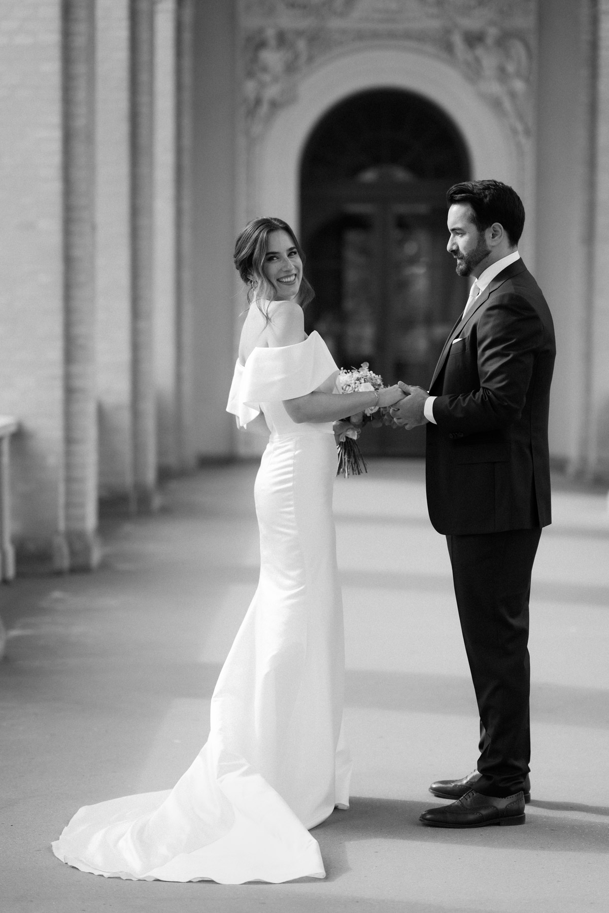 Glückliches Paar hält Hände: Detailaufnahme Eheringe und Brautstrauß