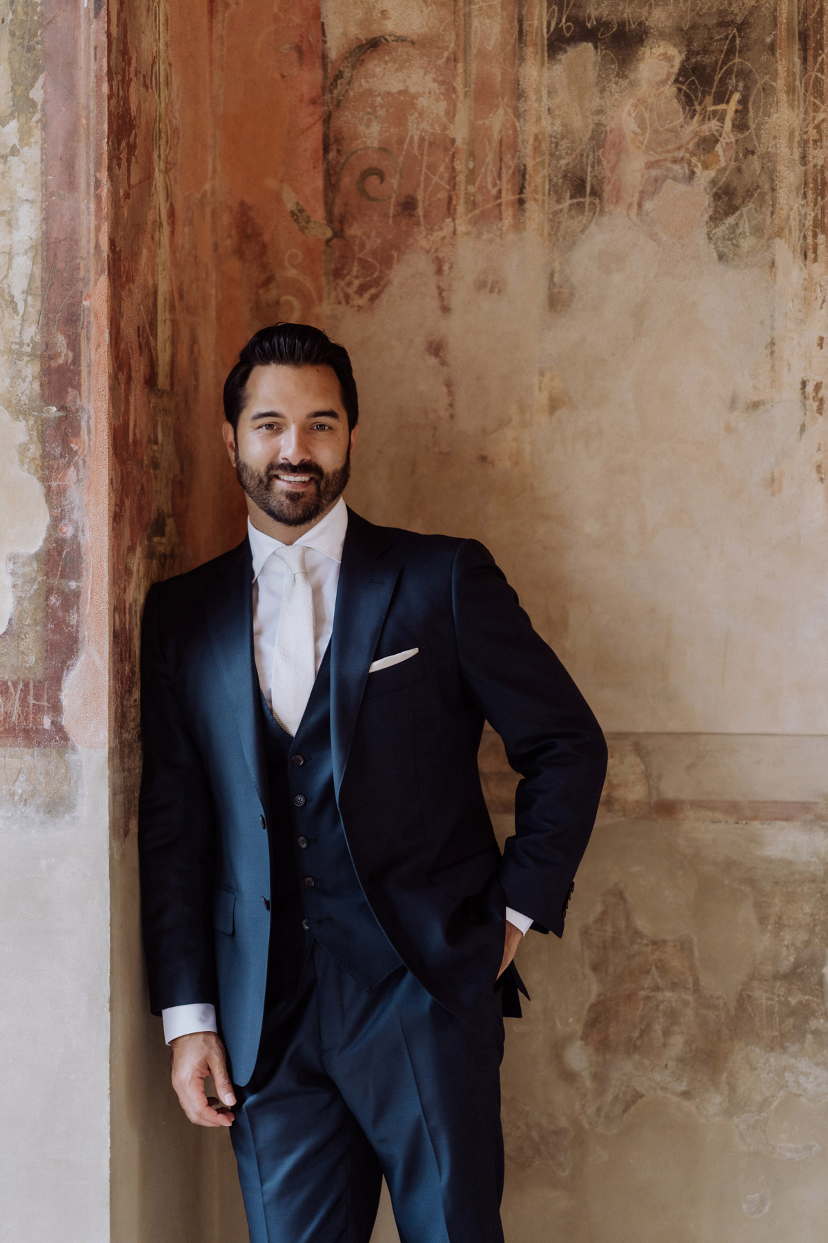 Bräutigam Fotoidee: Bräutigam lehnt natürlich an der Wand im Belvedere auf dem Pfingstberg.