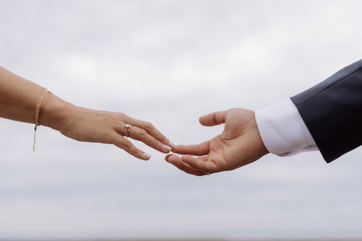 Hände mit Ehering berühren sich