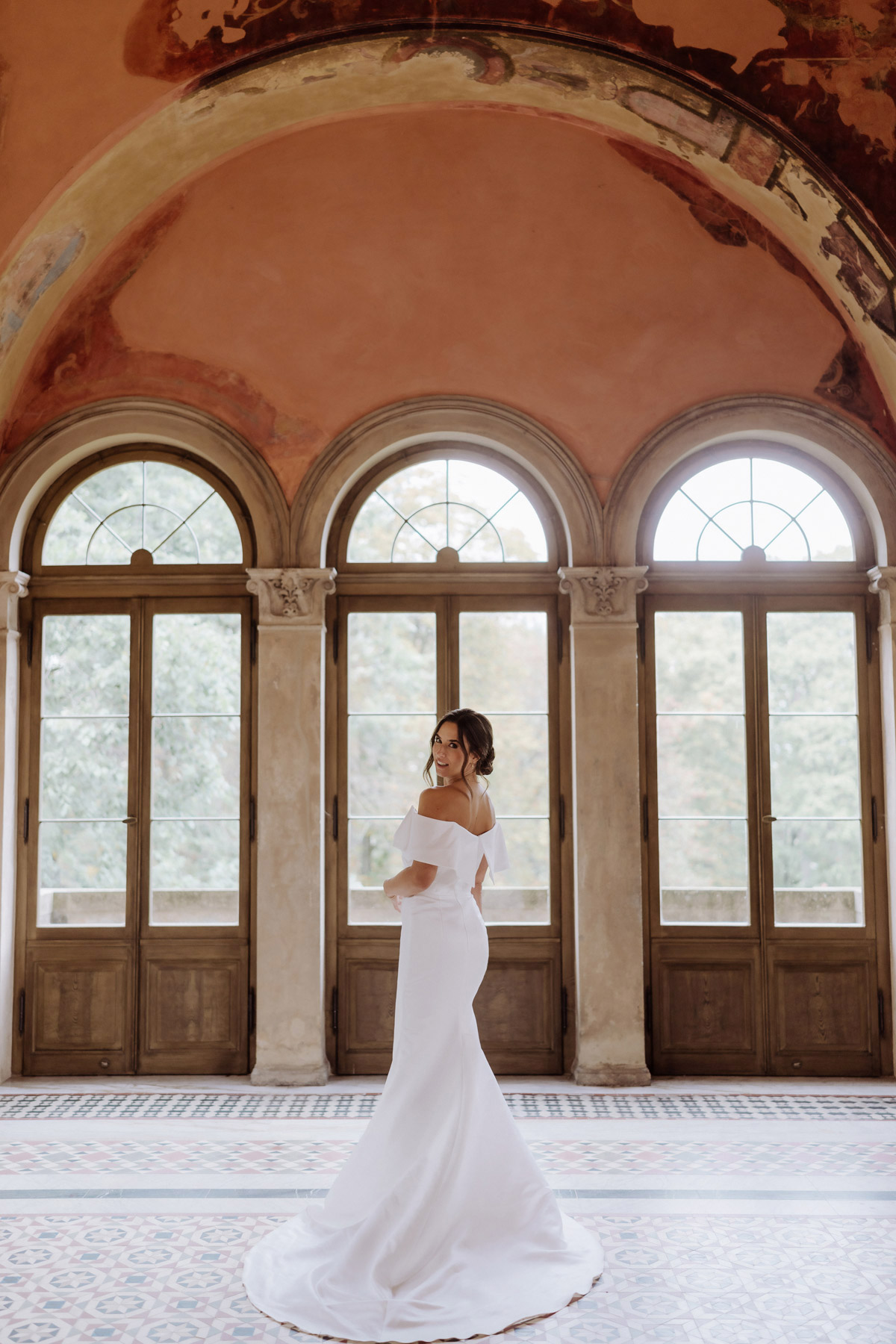 Brautpaarfoto in Potsdam vor Fenster des Schlosses Belvedere in Schwarz-Weiß