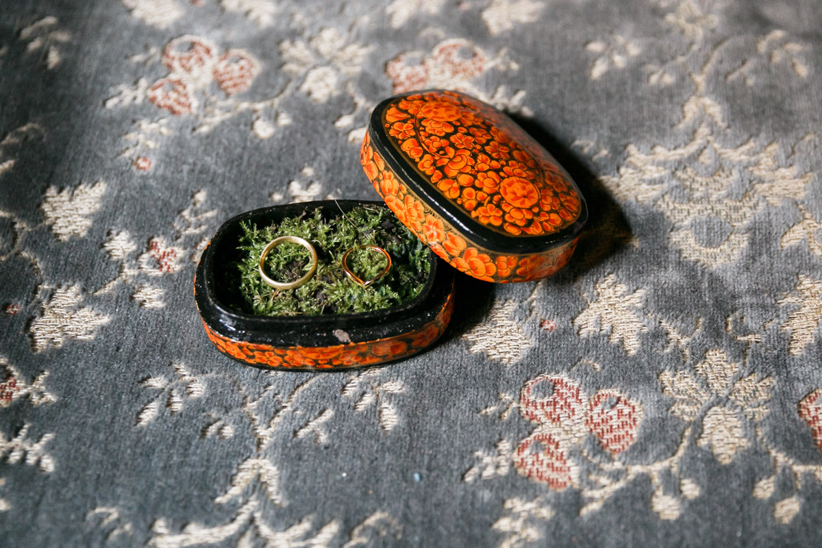 Detailfoto Eheringe in Lacquer-Box mit Moos auf Samtsofa