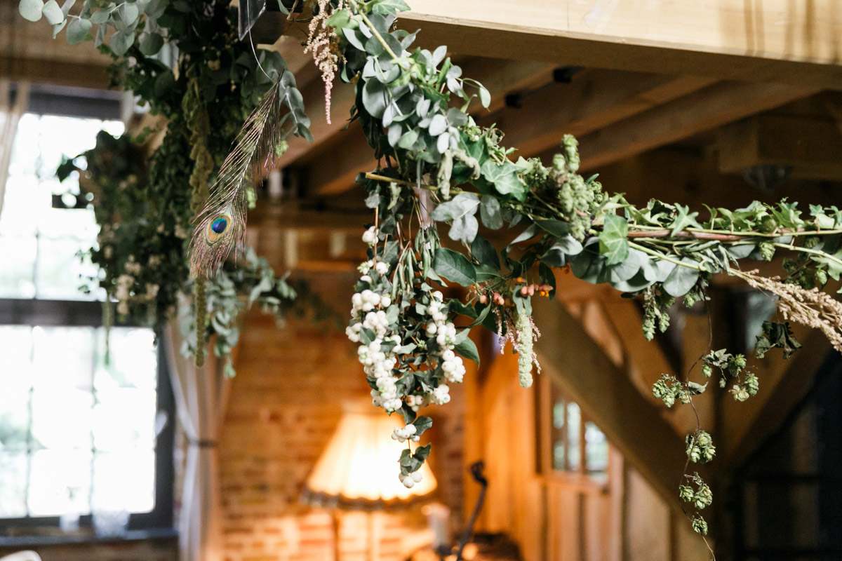 Dekoration aus Blättern, Beeren und Pfauenfedern bei Herbsthochzeit
