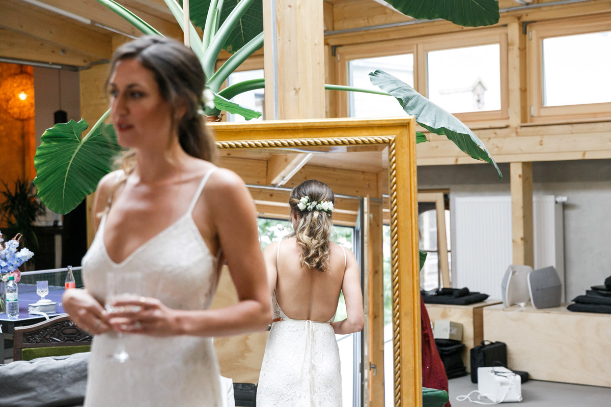 Braut von hinten im Spiegel beim Ankleiden
