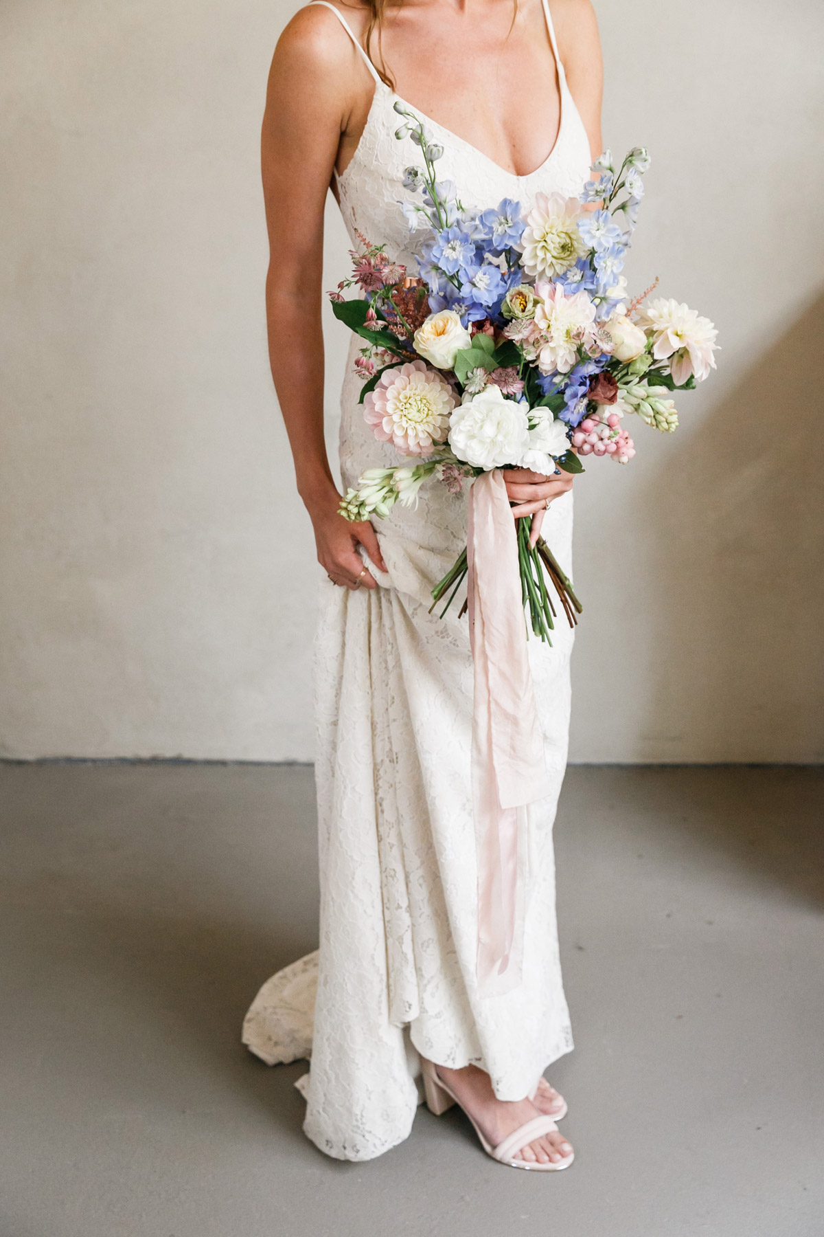 Braut mit üppigem Brautstrauß aus Herbstblumen in weiß, hellblau und zartrosa in der Alten Schmiede Berlin