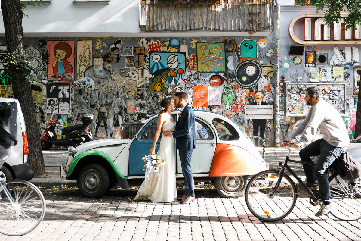 Urbanes Hochzeitsfoto vor Graffiti und alter Citroën-Ente bei Friedrichshain-Hochzeit