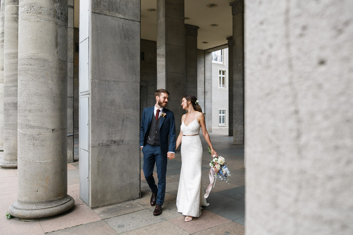 authentisches Brautpaarfotoshooting vor cleanem Säulen-Hintergrund in Berlin Friedrichshain