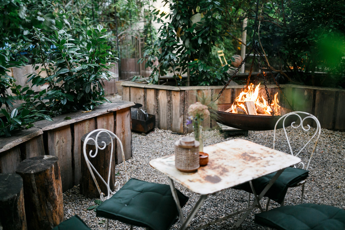 Gemütliche Hochzeitsfeier in Berlin: Romantische Abendstimmung mit brennender Feuerschale im versteckten Garten des Old Smithy's Dizzle