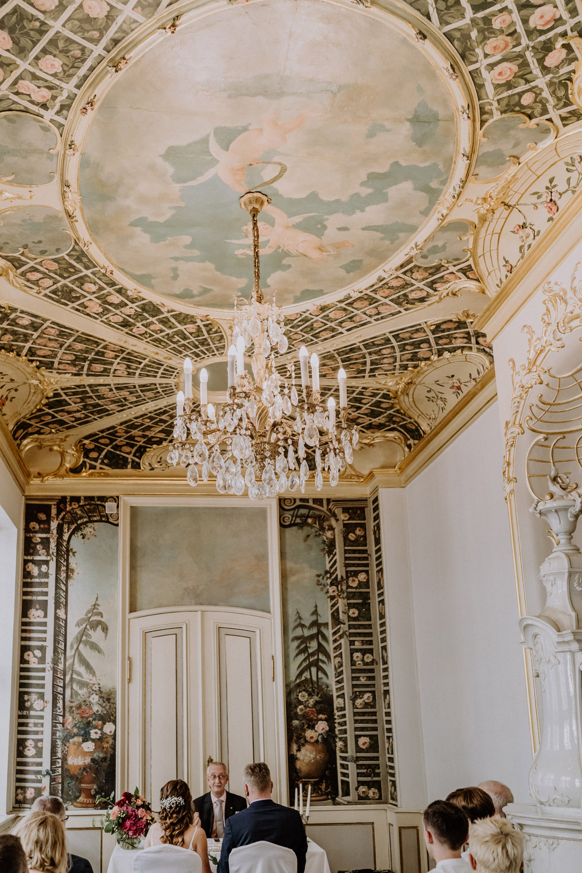 Heiraten im Ermelerhaus: Standesamtliche Trauung von Braut und Bräutigam unter dem prunkvollen Kronleuchter und der bemalten Decke